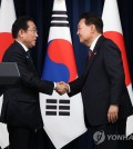 South Korean President Yoon Suk Yeol (R) and Japanese Prime Minister Fumio Kishida shake hands after holding a joint press conference at the presidential office in Seoul on May 7, 2023. During their talks, Yoon and Kishida agreed to allow a group of South Korean experts to visit Japan to inspect the planned release of radioactive water from the crippled Fukushima nuclear power plant. (Yonhap)