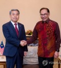 South Korean Defense Minister Lee Jong-sup (L) shakes hands with Malaysia's Prime Minister Anwar Ibrahim during their meeting in Langkawi, Malaysia on May 24, 2023, in this photo provided by Seoul's defense ministry. (PHOTO NOT FOR SALE) (Yonhap)