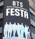 A tourist views an image of K-pop juggernaut BTS on a billboard in Seoul on June 12, 2023, as a two-week-long festival kicked off to celebrate its 10th debut anniversary. (Yonhap)