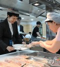 Senior presidential secretary for press affairs Kim Eun-hye (L) is served a tray of sliced raw fish at the in-house cafeteria of the presidential office in Seoul on Aug. 28, 2023, in this photo provided by the office. (PHOTO NOT FOR SALE) (Yonhap)