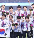 South Korean players and coaches celebrate their 2-1 win over Japan in the Asian Games men's football gold medal match at Huanglong Sports Centre Stadium in Hangzhou, China, on Oct. 7, 2023. (Yonhap)