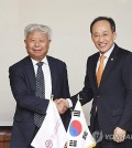 This photo, provided by South Korea's finance ministry, shows Finance Minister Choo Kyung-ho (R) shaking hands with Asian Infrastructure Investment Bank President Jin Liqun ahead of their meeting in Seoul on Nov. 27, 2023. (PHOTO NOT FOR SALE) (Yonhap)