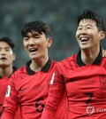 Son Heung-min of South Korea (R) smiles next to teammate Hwang In-beom (C) after scoring against Singapore during the teams' Group C match in the second round of the Asian World Cup qualification tournament at Seoul World Cup Stadium in Seoul on Nov. 16, 2023. (Yonhap)