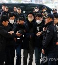 A man (4th from L, blurred) is taken by police investigators from Gangseo Police Station to Busan Metropolitan Police Agency in Busan on Jan. 2, 2024. The suspect is accused of stabbing opposition leader Lee Jae-myung in the neck during the politician's visit to Busan. (Yonhap)