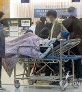 A patient and a doctor move about a hospital in Seoul on Feb. 27, 2024. (Yonhap)