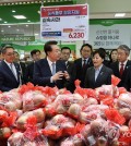President Yoon Suk Yeol (3rd from L) checks apple prices at an outlet of discount store chain Nonghyup Hanaro Mart in southern Seoul on March 18, 2024. (Pool photo) (Yonhap)