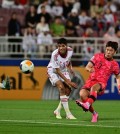 Hwang Jae-won of South Korea (R) fires a shot past Abdulla Hamad of the United Arab Emirates during the teams' Group B match at the Asian Football Confederation U-23 Asian Cup at Abdullah bin Khalifa Stadium in Doha on April 16, 2024. Photo provided by the Korea Football Association. (PHOTO NOT FOR SALE) (Yonhap)