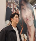 Kang Kang-hoon is seen in this photo with a giant portrait of his daughter at the BEXCO exhibition center in Busan, 320 kilometers southeast of Seoul, on May 10, 2024. (Yonhap)