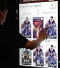 A man buys a ticket for "The Roundup: Punishment" at a movie theater in Seoul on May 9, 2024. (Yonhap)