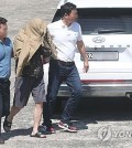 Police take a man covering his face with a jacket, one of the three suspects in the murder of a South Korean tourist in Thailand's Pattaya, to a police precinct for investigation in Changwon, about 300 kilometers south of Seoul, on May 13, 2024. (Yonhap)