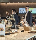 This photo, taken April 30, 2025, shows Kim Dong-won (3rd from L), chief global officer and president of Hanwha Life Corp., on a phone call, and Kim Dong-seon (4th from L), vice president and head of future vision at Hanwha Galleria Corp., waiting for a coffee order at a coffee shop in Josun Palace hotel in southern Seoul. The two were seen following their suspected meeting with Donald Trump Jr. to discuss potential business partnerships during his two-day visit to South Korea. (Yonhap)