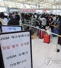 SK Telecom Co. subscribers wait in line to replace their USIM chips at Incheon International Airport, just west of Seoul, on April 30, 2025. (Yonhap)