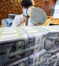 A banker checks dollars at Hana Bank's Counterfeit Notes Response Center in Seoul, in this file photo taken Dec. 19, 2024. (Yonhap)