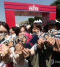 Japanese fans of K-pop boy group BTS show off their photo cards during the 2024 BTS Festa at Jamsil Sports Complex in southern Seoul, in this June 13, 2024, file photo. (Yonhap)